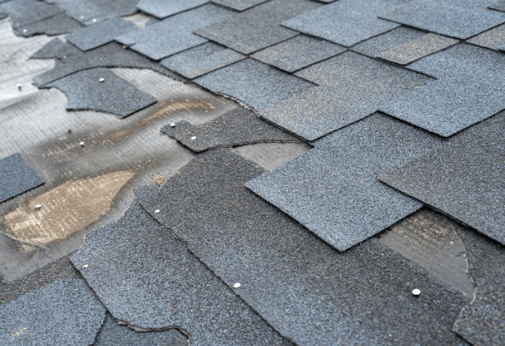 Damaged roofing shingles showing signs of wear and potential leaks, relevant to roofing maintenance and repair discussions.