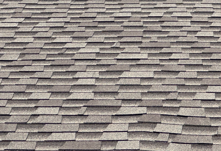 Wavy asphalt shingles on a roof, illustrating potential roofing issues relevant to home maintenance and repair discussions.
